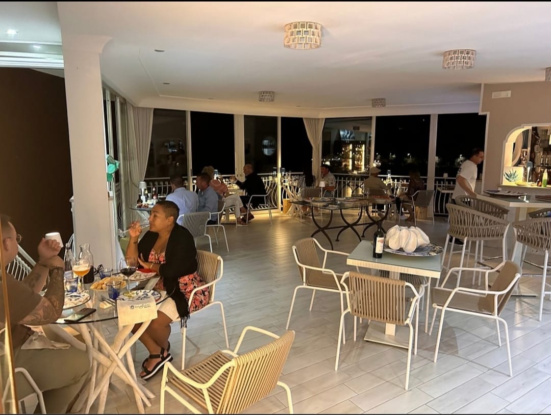 Ospiti a cena nella sala luminosa, di sera