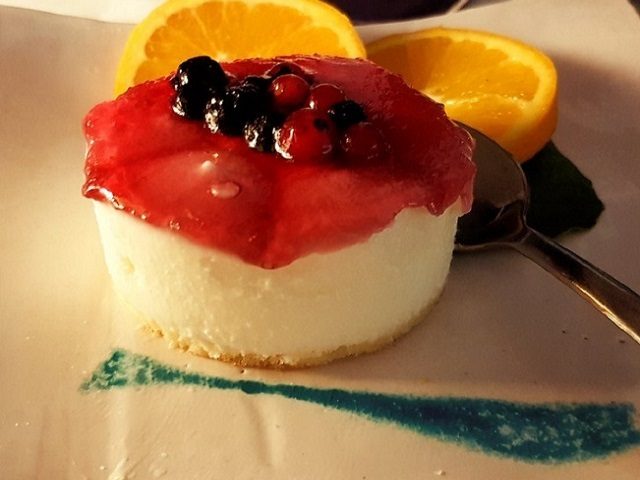 Dolce alla crema con salsa ai frutti rossi e fettine d&rsquo;arancia