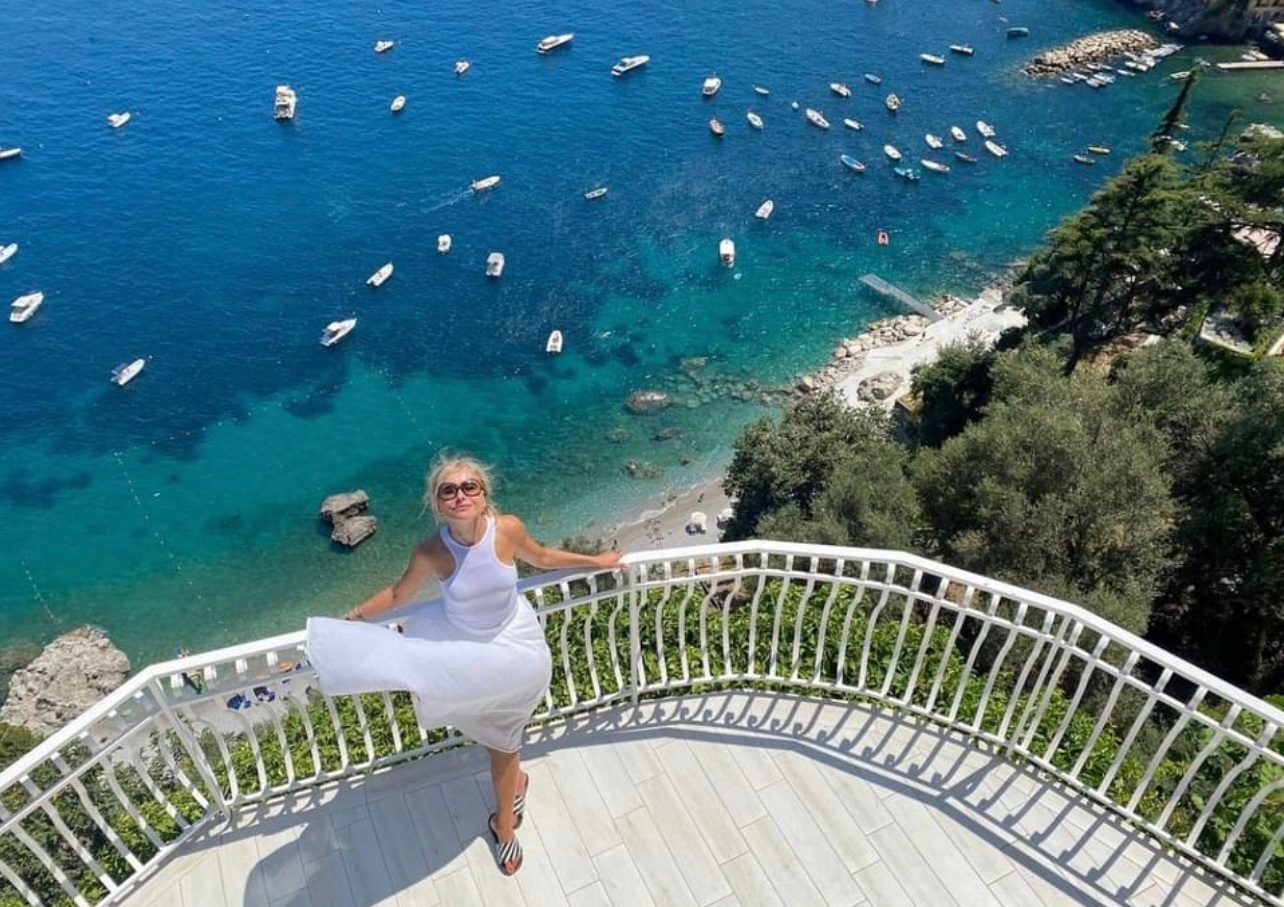 Ospite sulla terrazza panoramica sopra la baia, con barche sul mare turchese